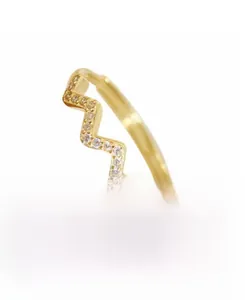 Vue macro d'une bague vague en argent S925 plaqué or avec pierres de zircone brillantes