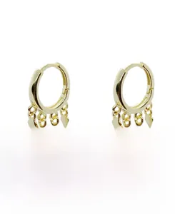 Détail de créoles dorées avec pendentifs à franges en forme de losange et pique