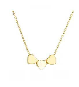 Detailed view of three connected gold heart pendants on a delicate link chain necklace
