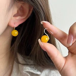 Detailed view of yellow agate drop earrings with s925 sterling silver hooks on model
