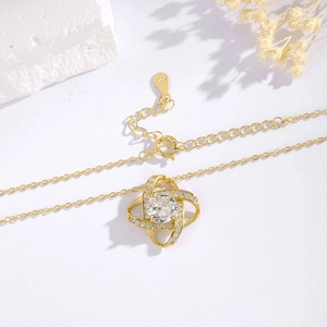 Macro detail of gold S925 silver clover necklace with cubic zirconia pavé setting