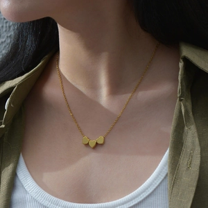 Elegant S925 sterling silver necklace with three gold heart pendants on model
