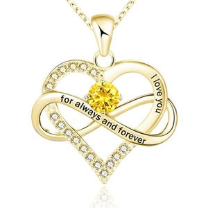 Detail of infinity heart pendant necklace in gold with yellow gemstone and romantic engraving
