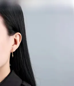 Close-up of a model wearing the gold lightning bolt charm hoop earring in S925 silver