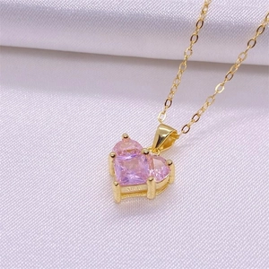 Elegant gold necklace with pink zircon heart pendant on white silk background