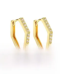 Macro detail of gold geometric hexagonal hoop earrings with clear sparkling zircons