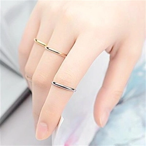 Detailed view of minimalist gold, silver, and rose gold slim rings worn on a hand