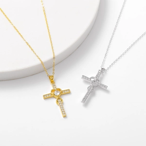 Close-up of 925 silver cross pendants with heart design and zircon stones