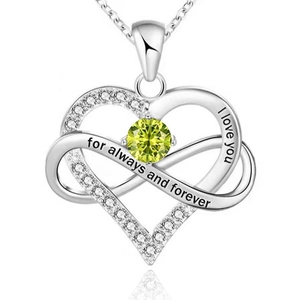 Macro shot of silver heart and infinity pendant with green gemstone and I love you engraving