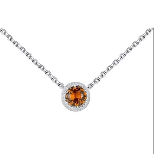 Macro shot of silver birthstone necklace with orange zircon pendant in rope edge setting