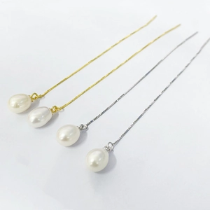 Detailed view of teardrop pearl drop earrings in gold and silver finish chain links