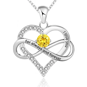 Close-up of silver heart necklace with infinity symbol and yellow gemstone inlay