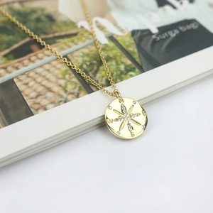 Detailed macro view of the gold S925 silver compass star pendant with sparkling cubic zirconia