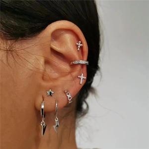Détail d'un ensemble de boucles d'oreilles en argent s925 avec croix et éclair en zircon