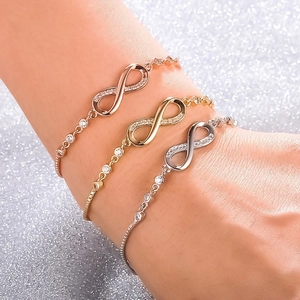 Détail de trois bracelets infini en or, argent et or rose avec des pierres en zircon