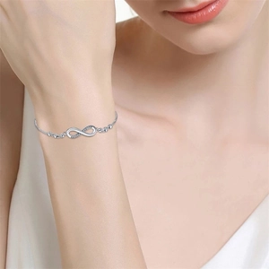 Détail du bracelet infini en argent serti de cristaux sur un poignet féminin