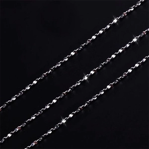 Macro shot of three minimalist S925 sterling silver necklaces on a deep black background