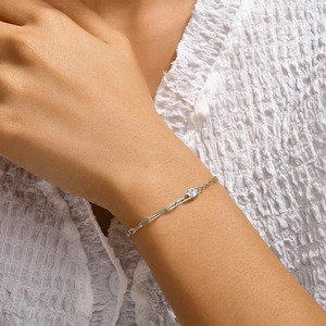 Detail of S925 sterling silver paperclip chain bracelet with a single four-prong solitaire