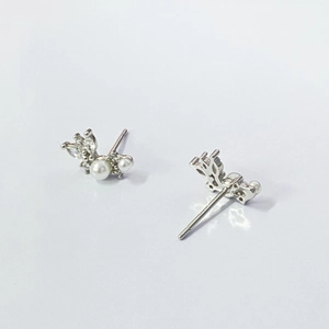 Macro detail of French vintage silver pearl earrings with zircon feather wing accents