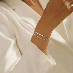 Close-up of minimalist S925 sterling silver double-layered snake chain bracelet on wrist