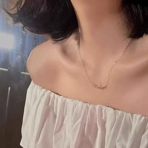 Close-up of minimalist S925 silver smile necklace with crystals on model's neckline