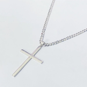 Close-up of polished S925 sterling silver cross pendant with a classic curb chain necklace