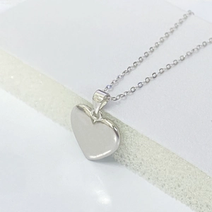 Close-up of polished S925 sterling silver heart pendant with reflective mirror finish