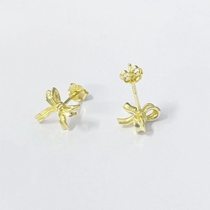 Macro shot of gold bow stud earrings with S925 sterling silver hallmark detail