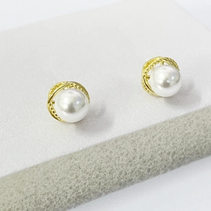 Detailed close-up of S925 sterling silver pearl stud earrings with twisted gold frame