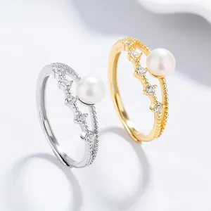 Detail of silver and gold wave rings with pearls and zircon stones for women