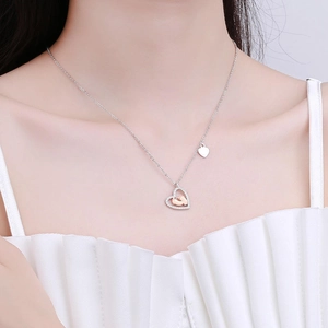 S925 sterling silver heart necklace with rose gold baby footprints on female model