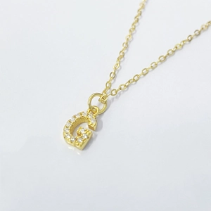 Detailed view of gold plated G initial necklace with shimmering zircon pave stones
