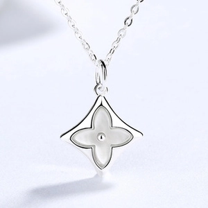 Macro detail of S925 sterling silver four-leaf clover pendant with white mother of pearl