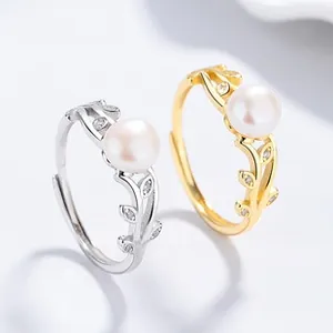 Detailed close-up of adjustable silver and gold leaf rings with pearls and sparkling crystals
