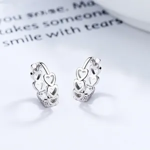 Macro shot of 925 sterling silver hoop earrings with hollow heart pattern detail