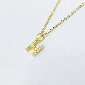 Detailed view of 18k gold plated H letter pendant with pavé cubic zirconia on fine chain