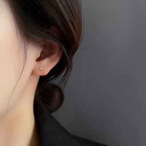 Gros plan d'une boucle d'oreille fleur en argent s925 avec zircon incrusté sur l'oreille