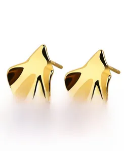 Detailed view of irregular ginkgo leaf stud earrings in polished gold finish