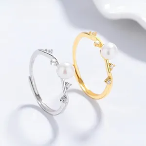 Detail of silver and gold wave rings with freshwater pearls and sparkling zircons