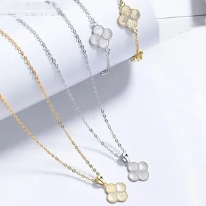 Detailed view of gold and silver four-leaf clover pendant necklace and bracelet set