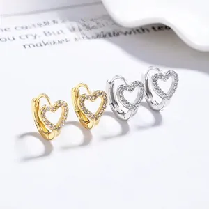 Detailed view of silver and gold heart earrings with sparkling cubic zirconia stones