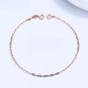 Detailed view of rose gold chain bracelet with hollow clover charm on blue background