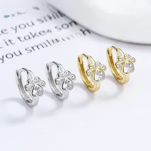 Detailed view of 925 sterling silver and gold paw print hoop earrings with zircon
