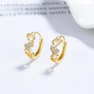 Close-up of gold-plated hollow heart earrings with sparkling white zircon stones
