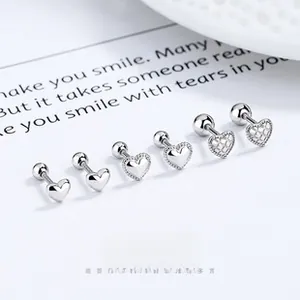 Detailed view of three pairs of silver heart screw-back earrings with textured finishes