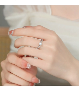 Detailed macro view of silver vine ring with white pearl and sparkling zircon accents