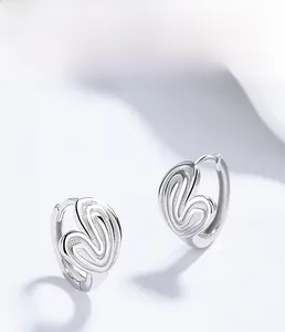 Macro shot showing hollow heart-shaped S925 sterling silver earrings with striped texture