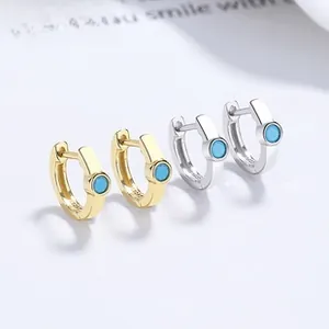 Detail of silver and gold 925 sterling silver hoop earrings with blue turquoise zircons