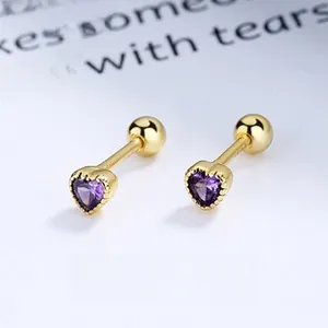 Detail of heart-shaped screw back earrings in gold finish with purple zircon stones