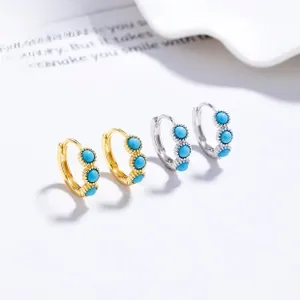 Detailed close-up of gold and silver S925 sterling silver hoop earrings with turquoise